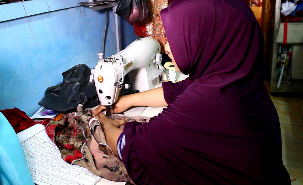 Dilla mengerjakan pesanan pakaian muslim. | Foto: Iman Jaya Lase
