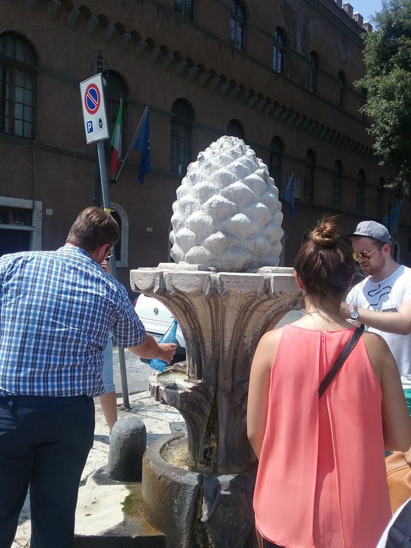 Para turis di tengah kota mengambil air minum yang disediakan.